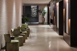 a corridor of a hotel lobby with green chairs at Rosa Grand Milano - Starhotels Collezione in Milan