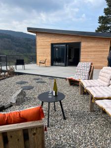 a patio with two chairs and a table with a bottle of wine at Chalet prestige climatisé avec sauna et Jacuzzi in Fréland