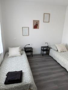 a room with two beds and two side tables at Maison moderne in Saint-Julien-de-Concelles