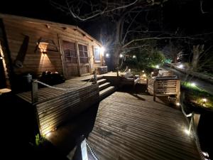 a wooden deck with a house at night at Chalet studio in Porto Ota +4 photos