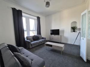 a living room with a couch and a tv at Modern Top Floor 2BR apartment in Montrose