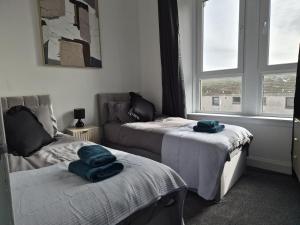 a room with two beds and a window at Modern Top Floor 2BR apartment in Montrose