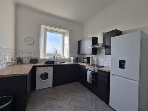 a kitchen with a white refrigerator and a dishwasher at Modern Top Floor 2BR apartment in Montrose +8 photos