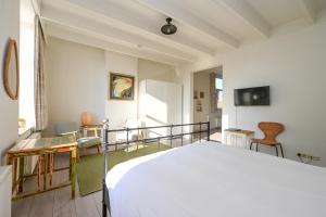 a bedroom with a bed and a table and chairs at Alta Mar Studios in Scheveningen