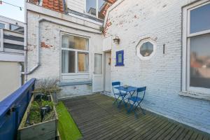 a patio with a blue table on a wooden deck at Alta Mar Studios in Scheveningen