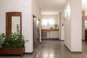 a hallway of a hospital with a mirror and plants at Residence Star in Turin
