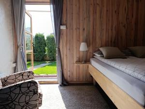a bedroom with a bed and a large window at TESLA Garden & Spa in Veternik