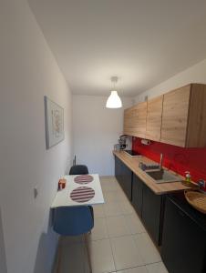 a kitchen with a counter and a table and chairs at Castle View Apartment in Malbork