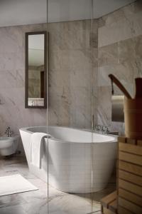 a white bath tub in a bathroom with a sink at Hotel Krallerhof in Leogang