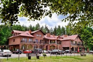 a large building with cars parked in front of it at Hotel Galicja in Ulanów