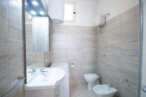 a bathroom with a sink and a toilet at SA DOMU DE S'ORTU in Bari Sardo