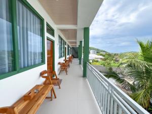 a balcony with benches and tables on a building at La Casa de Maria in Komodo Labuan Bajo Airport