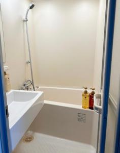 a bathroom with a white tub and a sink at 亀井町Stay201 in Takamatsu