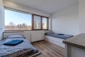 two beds in a room with two windows at Apartmány Holiday in Ostrava