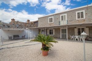 a house with a palm tree in front of it at SA DOMU DE S'ORTU in Bari Sardo
