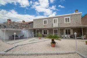 a large stone house with a courtyard with chairs at SA DOMU DE S'ORTU in Bari Sardo