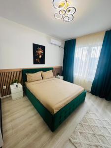 a bedroom with a large bed with blue curtains at RxM HOME CITY in Chiajna