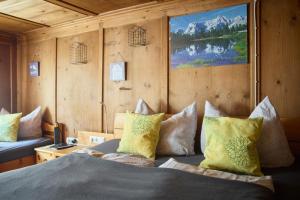 a bedroom with a bed with pillows and a couch at Landhaus-Willi in Gaschurn