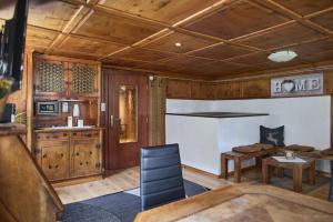 a living room with wooden walls and a kitchen at Landhaus-Willi in Gaschurn