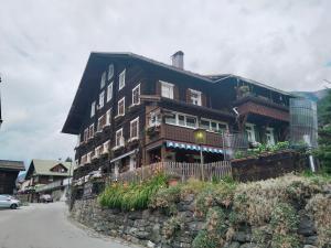 a large wooden house on top of a stone wall at Landhaus-Willi in Gaschurn