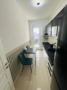a kitchen with a table and a green chair at RxM HOME CITY in Chiajna