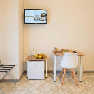 a room with a table and a television on the wall at Melo Accommodations in Bari