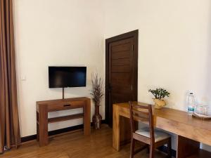a room with a desk with a television and a table with a chair at TSIAZOMPANIRY ISLAND LODGE in Ambohimiadana