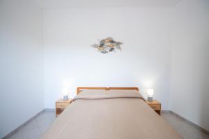 a bedroom with a bed with two candles on it at SA DOMU DE S'ORTU in Bari Sardo