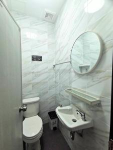 a bathroom with a toilet and a sink and a mirror at The One Hotel in Pattaya