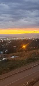 a view of the sunset from a hill with a road at Maple Lane Stays in Nakuru