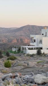a white building with a mountain in the background at Horizon Villa in Qurayyah