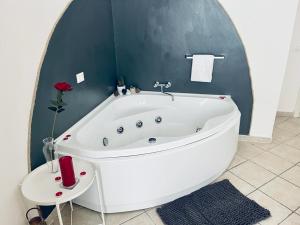a white bath tub in a bathroom with a mirror at Jacuzzi Suite in Livorno