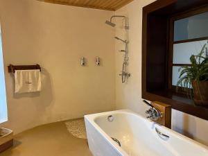 a bathroom with a bath tub and a window at TSIAZOMPANIRY ISLAND LODGE in Ambohimiadana +67 photos