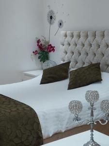 a bedroom with a white bed with a tufted headboard at Modern Studio Near Gatwick in London Gatwick Airport