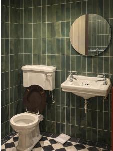 a green tiled bathroom with a toilet and a sink at The Scarlet Bath in Bath