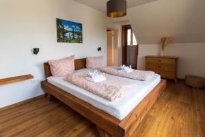 a bedroom with a large bed with pink pillows at Wolke 7 – PEAK Andreasberg in Sankt Andreasberg