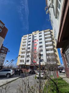 a tall white building with a red sign on it at Gabala Tufandag City Hotel in Gabala