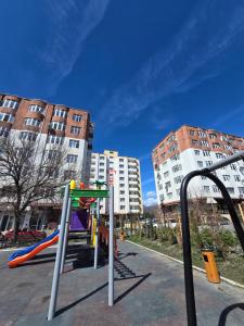a playground in a city with tall buildings at Gabala Tufandag City Hotel in Gabala