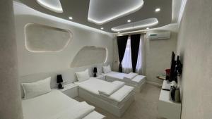 a room with two white couches and two windows at Ohu Palace Hotel in Fergana