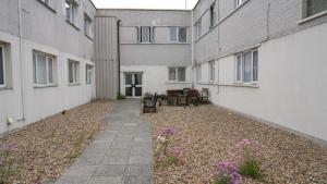 an empty courtyard of an apartment building with flowers at Modern Studio Near Gatwick in London Gatwick Airport