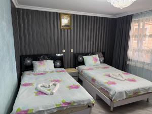 two beds in a room with hearts made out of towels at tamazis guest house in Batumi