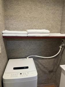 a shelf with towels on top of a toilet at 亀井町Stay202 in Takamatsu