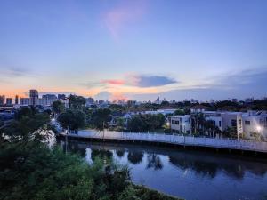 a bridge over a river with a city in the background at Cozy Breeze Onnut 21 in Amphoe Phra Khanong
