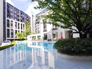 a large swimming pool in a city with buildings at Cozy Breeze Onnut 21 in Amphoe Phra Khanong +18 photos