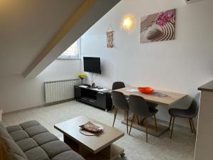 a living room with a couch and a table at Apartments Amela in Pula