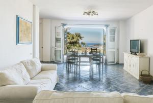 a living room with a couch and a table at Casa del passero - Villa with Infinity Garden and Sea View in Forio d'Ischia