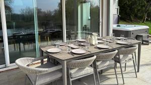 a wooden table with chairs and glasses on it at The Nait in Fladbury