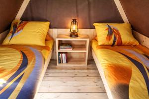 a room with two beds and a night stand with a lamp at Pension Javorník in Jeřmanice +17 photos
