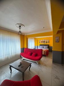 a living room with a red couch and a bed at İlkadım Suit Apart in Samsun