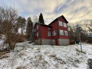 a red house in a field with snow on the ground at Workers Stay - Housing for Workers Olofstorp Göteborg in Olofstorp